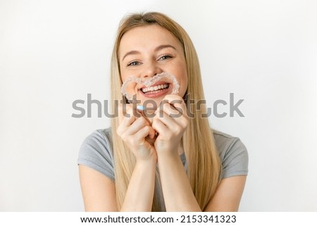 Happy girl making a heart shape with her invisible silicone aligners for dental correction. Dental treatment. mobile orthodontics. Royalty-Free Stock Photo #2153341323