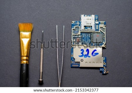 Repair of mobile phones and various electronic gadgets. The chip from the electronic device lies on the table on a black background.