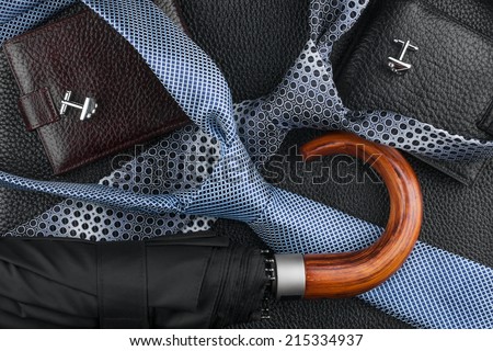  Wallet, tie, cufflinks, umbrella lying on the skin, can be used as background Royalty-Free Stock Photo #215334937