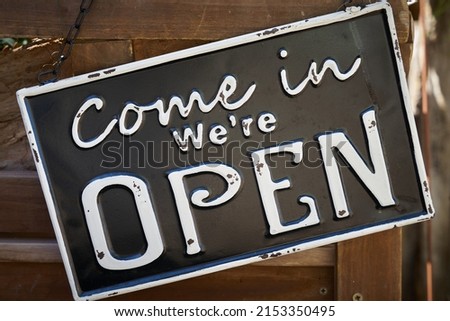  Sign on the front door of a store with the words Come in we are open                              