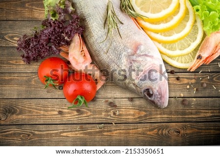 Fresh Fish with spice and lemon on desk Royalty-Free Stock Photo #2153350651