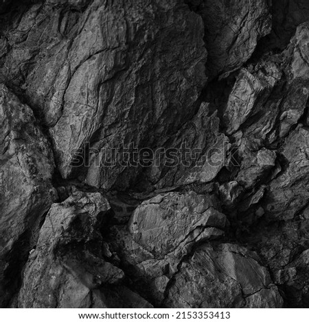   Black white rock texture. Rough mountain surface. Close-up. Dark volumetric stone background with space for design. Crumbled. Weathered.                               Royalty-Free Stock Photo #2153353413