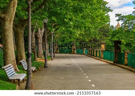 Tree lined alley in the Media Luna Park leading up to the Cathedral of Pamplona, Navarra, Spain town famous for the running of the bulls Royalty-Free Stock Photo #2153357163
