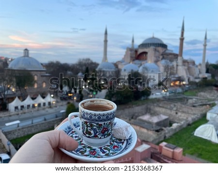 hand of tourist with turkish tradituional coffee drink on background of the hagia sophia cathedral church, Istanbul Turkey