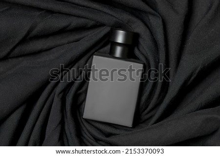 black perfume bottle on a black cloth background
 Royalty-Free Stock Photo #2153370093