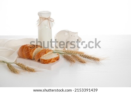 Dairy products on white wooden table, wheat ears, white cow figurine.  Symbols of Jewish holiday - Shavuot