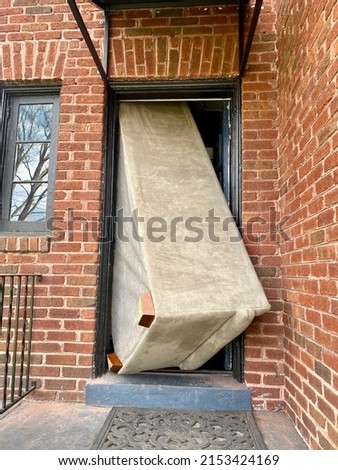 Large couch that will not fit through the doorway of a building Royalty-Free Stock Photo #2153424169