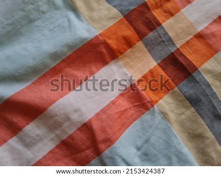 Abstract background textured white sarong with color combinations of lines forming a box 