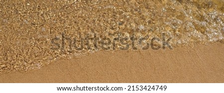 Bright sandy beach in summer sunny day. Soft water waves. Holidays concept.  Theme of summer holidays. The beauty in nature. Close up photography. Panorama. Sunny