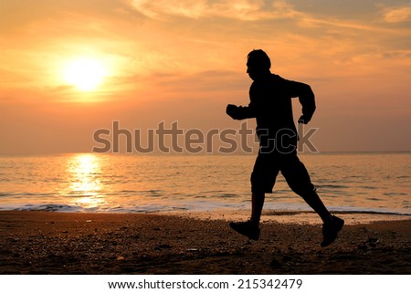 Silhouette man running at the beach 
