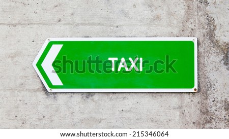 Green sign on a concrete wall - Taxi