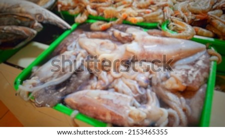 Defocused abstract background of squid on display in fish market.