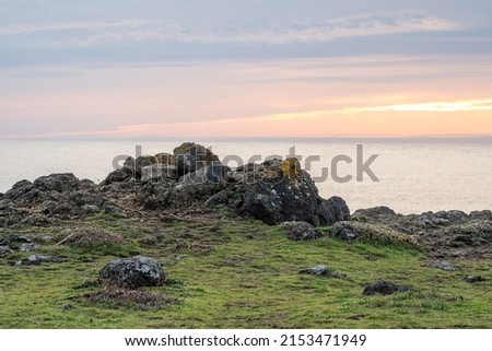 rocky cliffs edge over ocean sunset Royalty-Free Stock Photo #2153471949