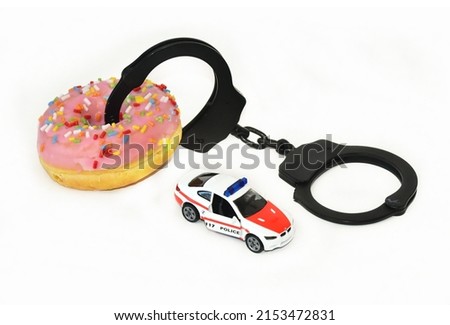 funny handcuffs with police toy car and donut