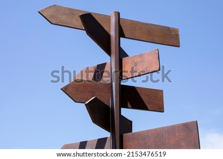 wood highway direction arrows with blue sky