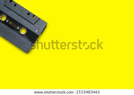 Old compact cassette tape on yellow background