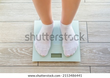 Woman's feet in white socks standing on a electronic floor scales Royalty-Free Stock Photo #2153486441