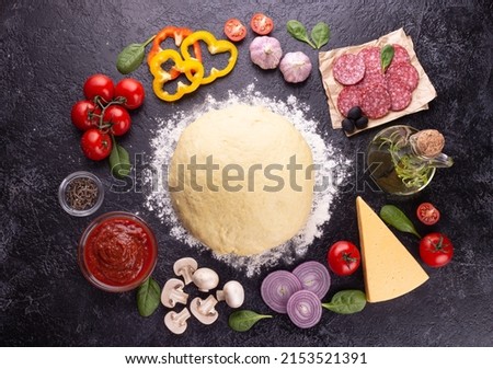 Food ingredients and spices for cooking mushroom, tomato, cheese, onion, oil, pepper, salt, basil, olive and delicious Italian pizza on a black concrete background. Copyspace. View from above. Banner Royalty-Free Stock Photo #2153521391