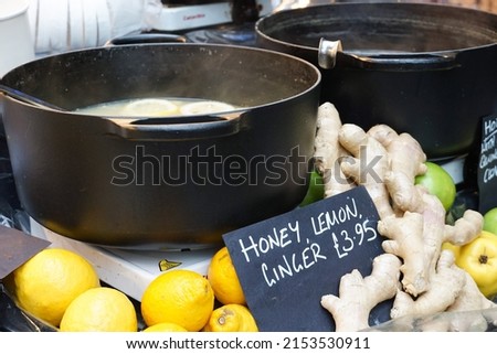 Cast iron pots of honey, lemon and ginger hot drink on display at Borough Market in London. Image has copy space.
