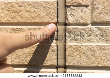 Image of a man inspecting caulking on the outer wall Royalty-Free Stock Photo #2153532233