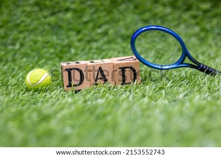 Tennis Dad is on green grass . A tennis dad usually is someone who enthusiastically and actively supports his child or children's involvement and development in tennis. 