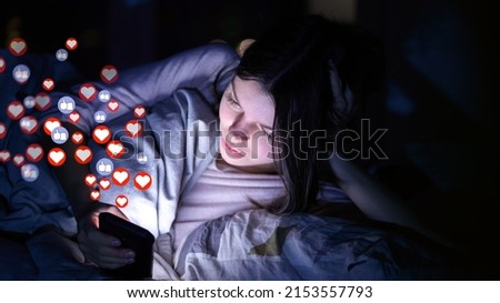 Young girl lies in bed at night with a mobile phone and sends or receives likes and hearts on social networks, a woman publishes news, the symbols of hearts and likes are added over image.