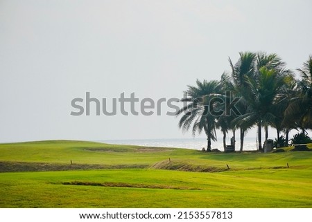 Golf course with a rich green turf beautiful scenery, blue sky and beach at the background. Golf court at Mahabalipuram, Tamilnadu, India.