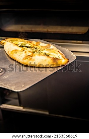 chef baker making pide at kitchen. Put on landing shovel and send it to the oven.