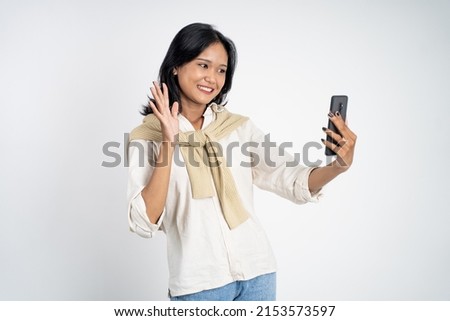 young woman make a video call using mobile phone with saying hello gesture on isolated background