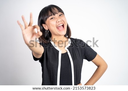 Young woman smiling with okay hand gesture on isolated background