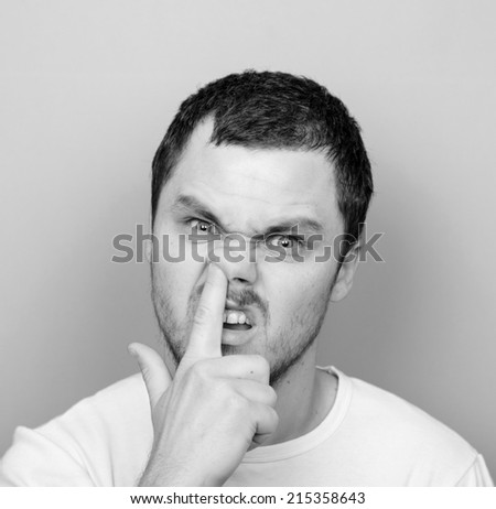 Portrait of a funny guy with finger in his nose - Monochrome or black and white portrait