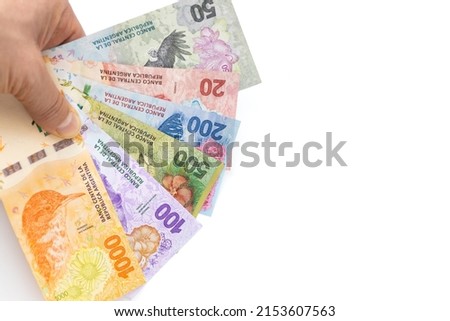 Argentinian money held in the hand, all banknotes from the new animal series, white background, space for text