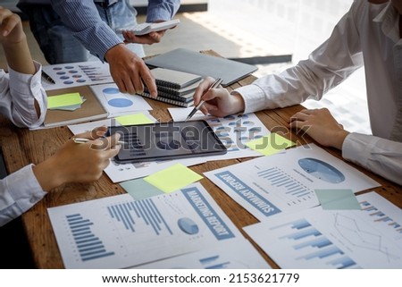 Financial analysts analyze business financial reports on a digital tablet planning investment project during a discussion at a meeting of corporate showing the results of their successful teamwork. Royalty-Free Stock Photo #2153621779