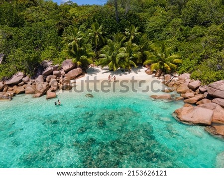 Praslin Seychelles tropical island with withe beaches and palm trees, couple of men and women mid age on vacation at Seychelles visiting the tropical beach Anse Lazio Praslin Seychelles. drone view  Royalty-Free Stock Photo #2153626121