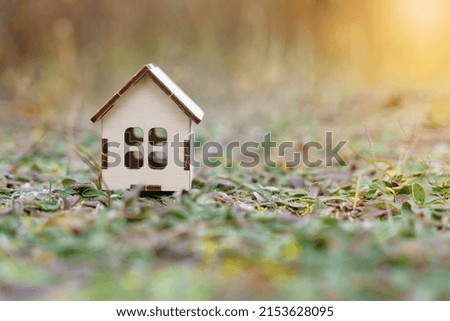 Eco home concept. There is a small wooden house on the grass.
