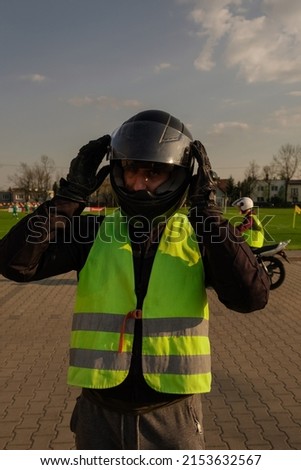 A student of a motorcycle school is preparing to ride. The biker adjusts his helmet and once again. The process of preparing for riding a motorcycle.