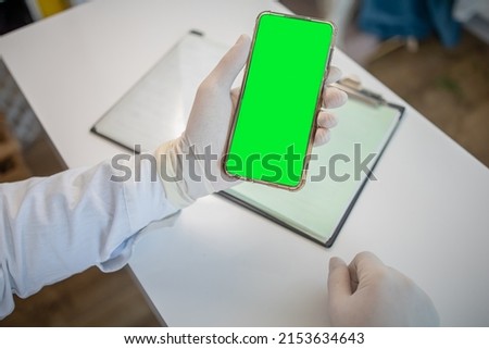 Elderly patients use their mobile smartphone to contact relatives and consult with treatment in a hospital or clinic. doctor holds phone with green screen
