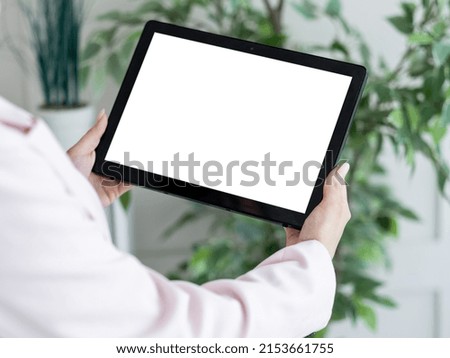 Virtual life. Digital mockup. Computer connection. Unrecognizable woman holding tablet computer with blank screen in light room interior.