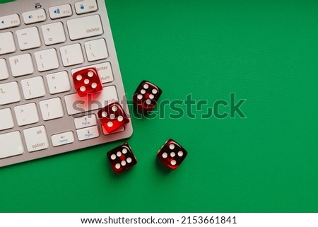 Online casino concept. Five red dice on keyboard.