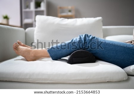 Woman Using Footrest To Reduce Back Strain And Feet Fatigue Royalty-Free Stock Photo #2153664853