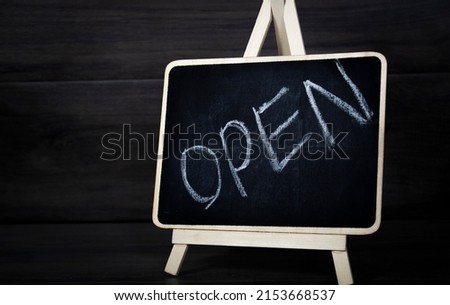 lettering open on black board