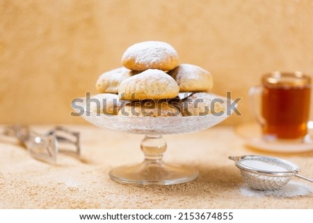 traditional Islamic Feast,Cookies for celebration of Eid El Fitr (Kahk) dusted with fine sugar with a cub of tea in the background  Royalty-Free Stock Photo #2153674855