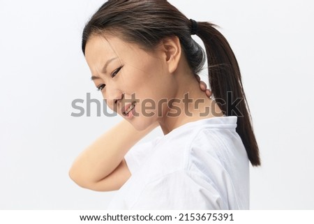 Neck ache. Tormented from fibromyalgia tanned beautiful young Asian woman rubbing massaging tensed muscles posing isolated on white background. Injuries Poor health Illness concept. Cool offer Banner