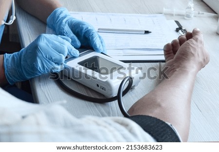 Young girl doctor or pharmacist measures the patient's pressure at home. Provision of medical services at home. Family doctor. Healthcare concept. Royalty-Free Stock Photo #2153683623