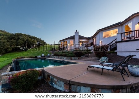 Twilight Photo of the Pool, Rear Patio, and Back Yard of a Gorgeous 4,000 sq ft Custom New Home on Private 600 Acre Lakeside Marin Property Royalty-Free Stock Photo #2153696773