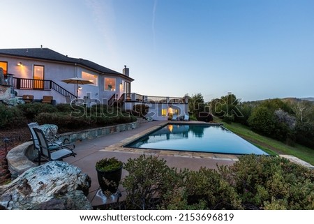 Twilight Photo of the Pool, Rear Patio, and Back Yard of a Gorgeous 4,000 sq ft Custom New Home on Private 600 Acre Lakeside Marin Property Royalty-Free Stock Photo #2153696819