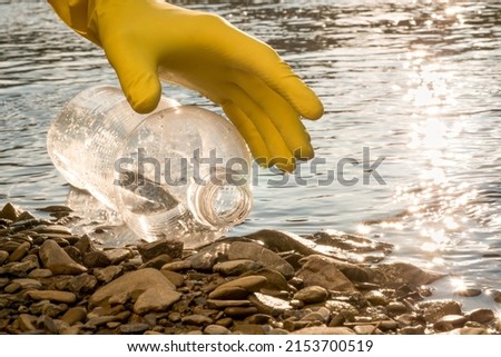 Volunteer cleaning river trash pick up litter picking shore. Collect garbage river. Picking up garbage water plastic nature. Cleaning beach waste plastic bottle PET. Cleaning trash beach garbage shore Royalty-Free Stock Photo #2153700519