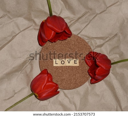 Valentine's Day greeting card with a  red tulips on a textured background . Text Love