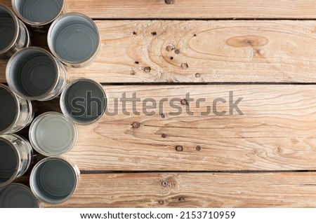 recycled cans, reused on a table with a brown background
top view, space for text.