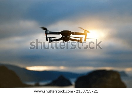 Foldable drone copter flying with a digital camera in mountains